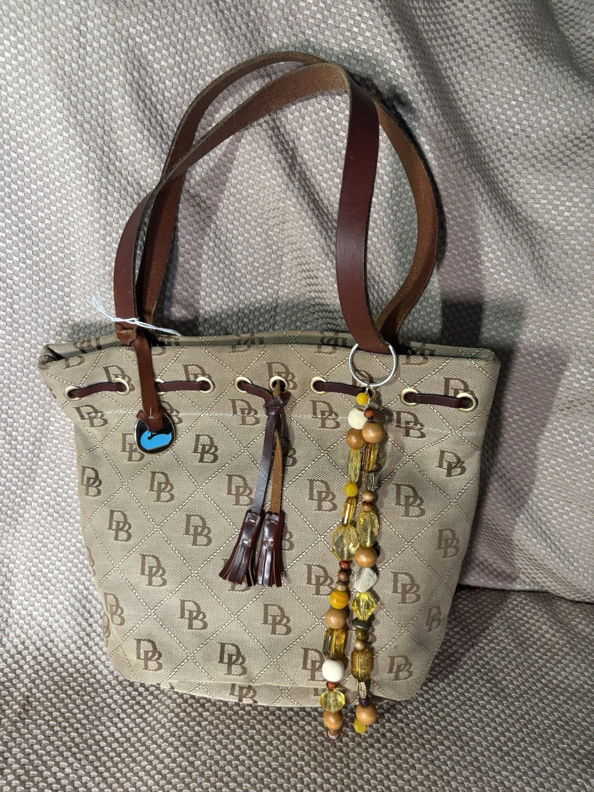 Dooney & Bourke Monogram Tote Bag Drawstring Gold Hardware Tassel Charm Beige